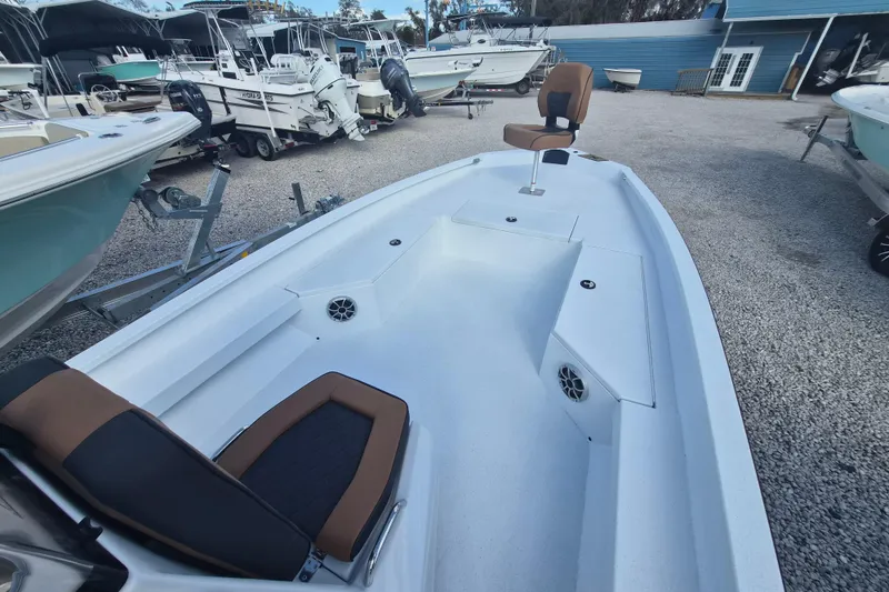 Slide: The Image of 2026 Xpress H24B Bay boat interior with seating, surrounded by other boats in a marina. - 8