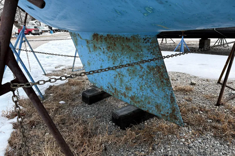 Slide: The Image of Rusty keel of a 1988 Hunter 28.5 sailboat on a gravel surface. - 14