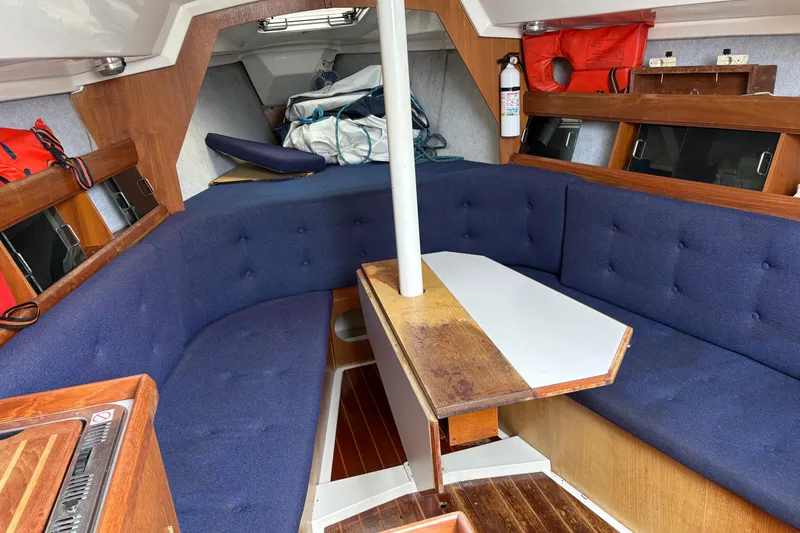 Slide: The Image of Interior of 1988 Hunter 28.5 sailboat with blue seating and wooden table. - 3