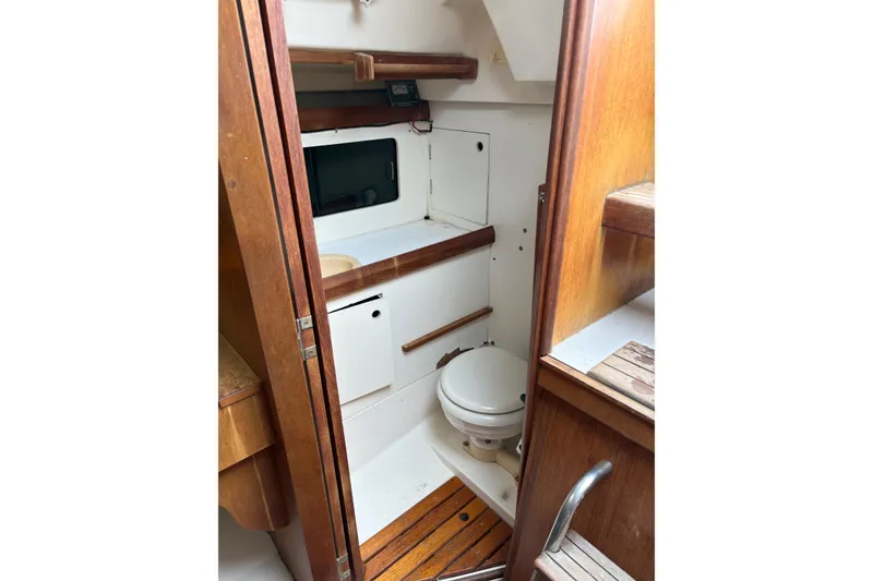 Slide: The Image of 1988 Hunter 28.5 sailboat interior bathroom with wooden accents and compact design. - 4