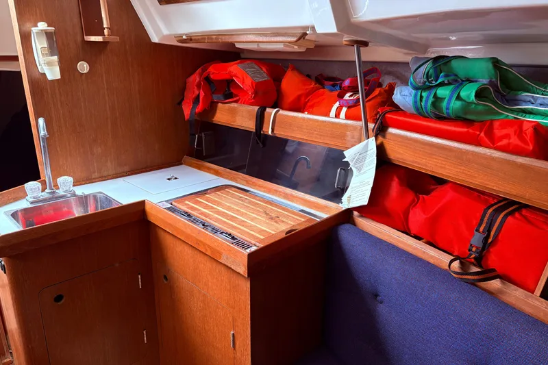 Slide: The Image of Interior of 1988 Hunter 28.5 sailboat with kitchen and life jackets stored above. - 6