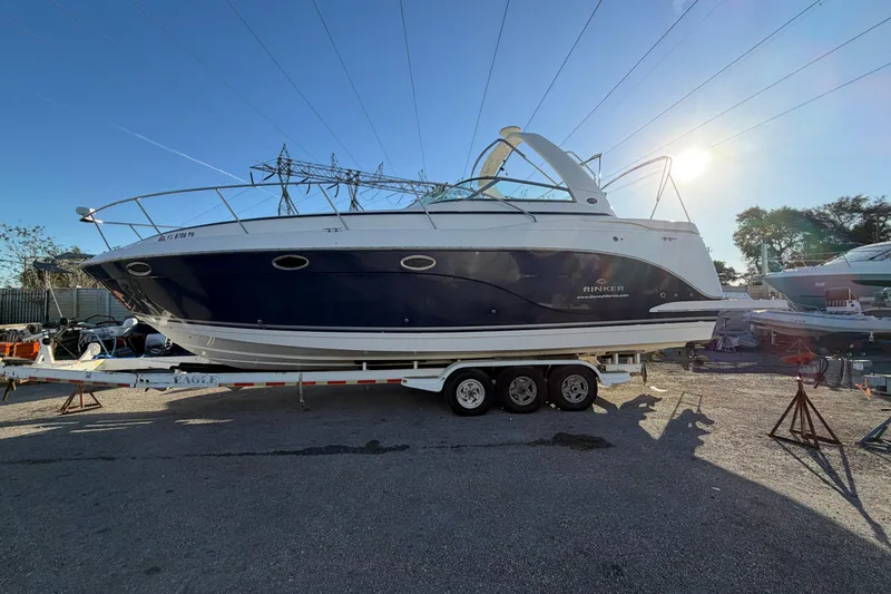 The Image of 2007 Rinker EX 370 boat on trailer under clear blue sky. - 0
