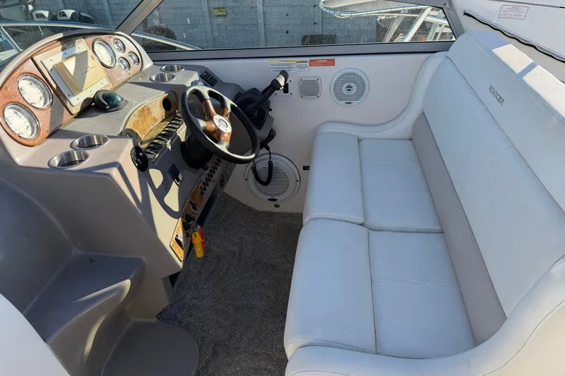 Slide: The Image of Interior of a 2007 Rinker EX 370 boat with white seating and control panel. - 11