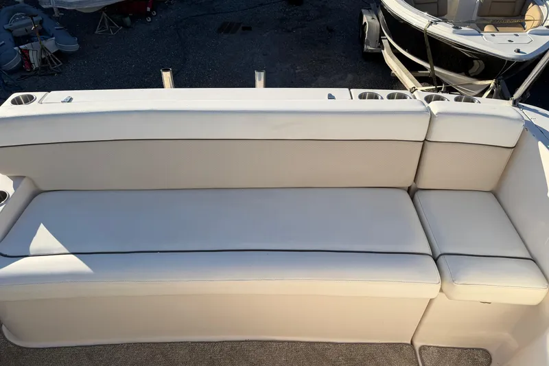 Slide: The Image of 2007 Rinker EX 370 boat seating area with white upholstery and cup holders. - 14