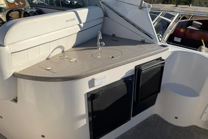 Slide: The Image of 2007 Rinker EX 370 boat interior with kitchenette and seating area. - 16