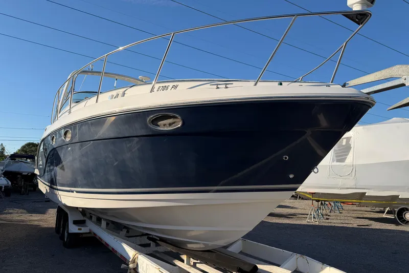 Slide: The Image of 2007 Rinker EX 370 boat on trailer, blue and white hull, parked outdoors. - 2