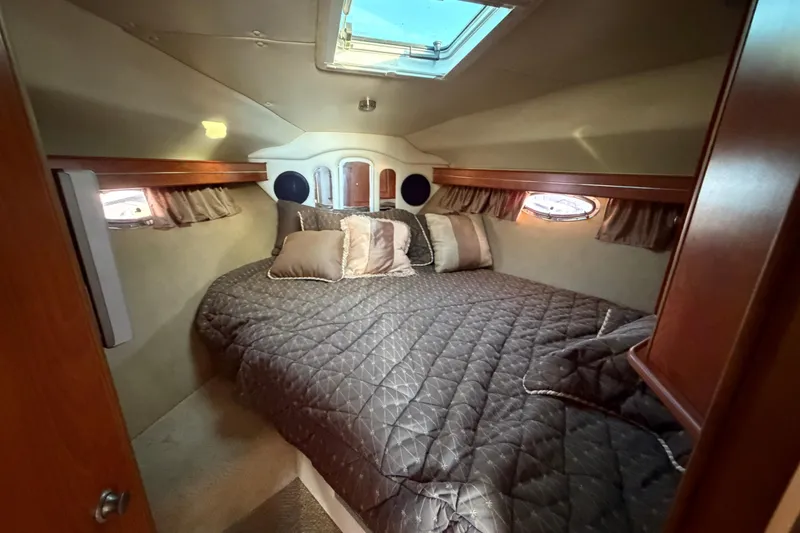 Slide: The Image of Luxurious cabin interior of 2007 Rinker EX 370 yacht with cozy bedding and porthole windows. - 22