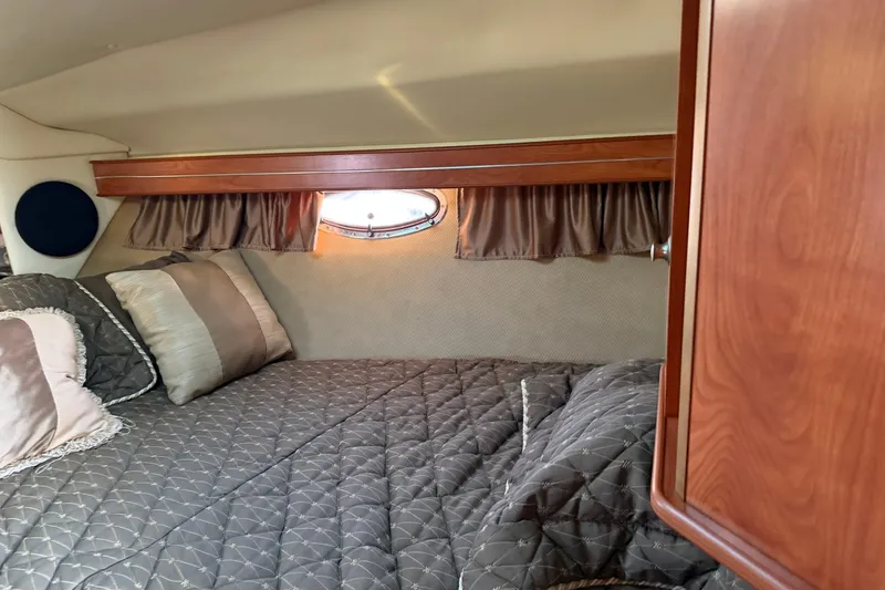Slide: The Image of Cozy cabin interior of 2007 Rinker EX 370 with elegant bedding and wood accents. - 25