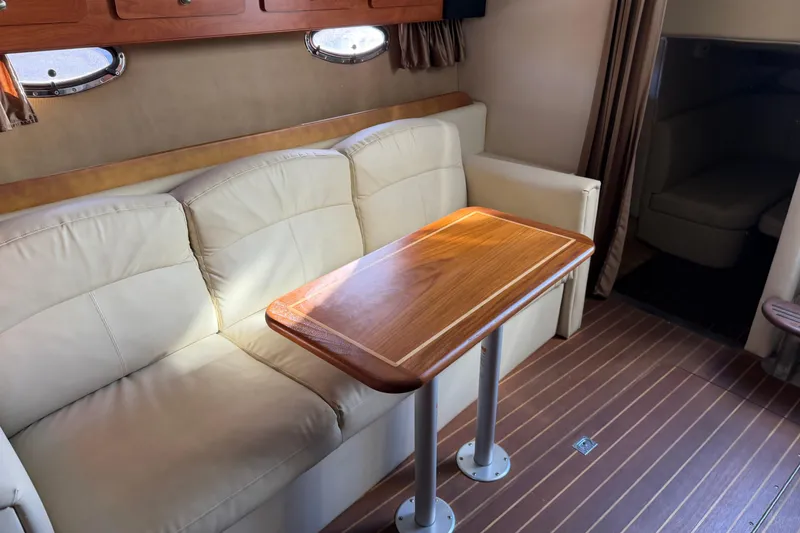 Slide: The Image of Interior of 2007 Rinker EX 370 boat with beige sofa and wooden table. - 26