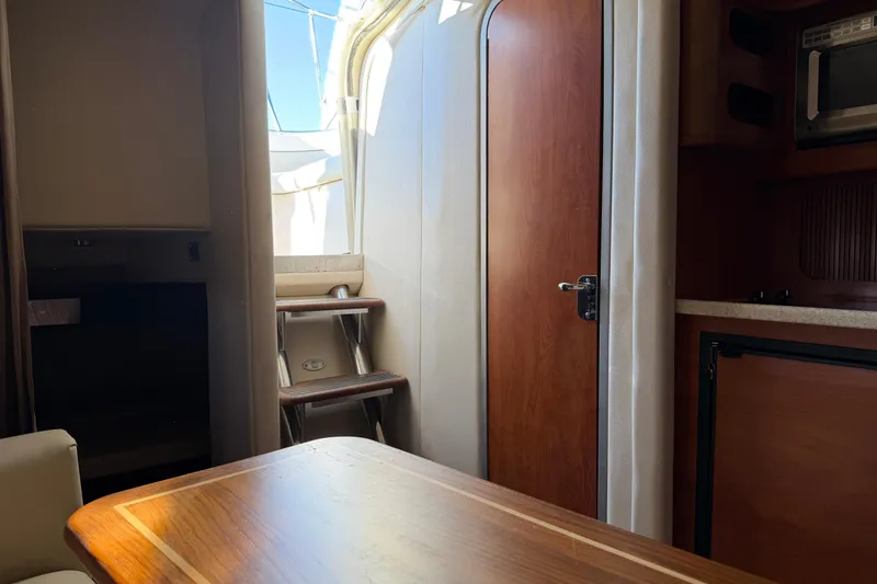 Slide: The Image of Interior of 2007 Rinker EX 370 boat with wooden table and compact kitchen area. - 28