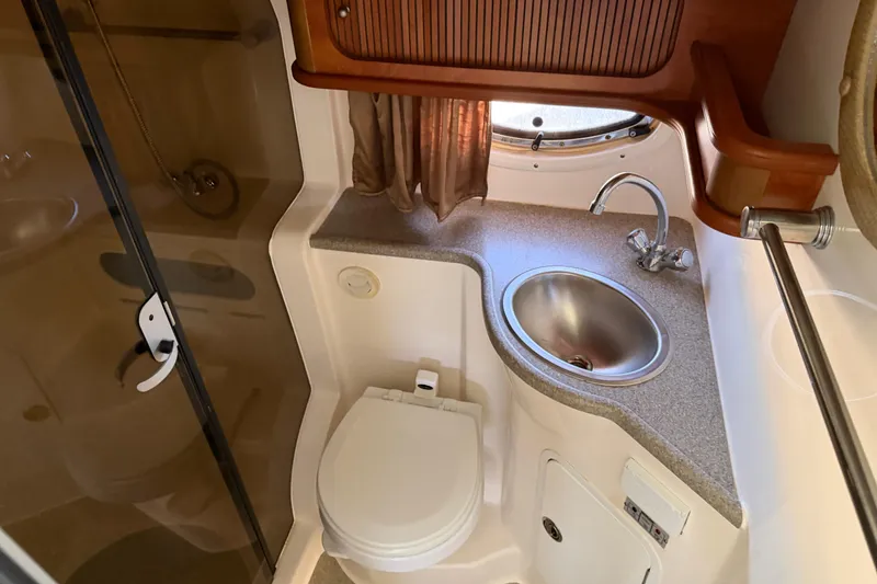 Slide: The Image of 2007 Rinker EX 370 boat bathroom with sink, toilet, and shower area. - 29