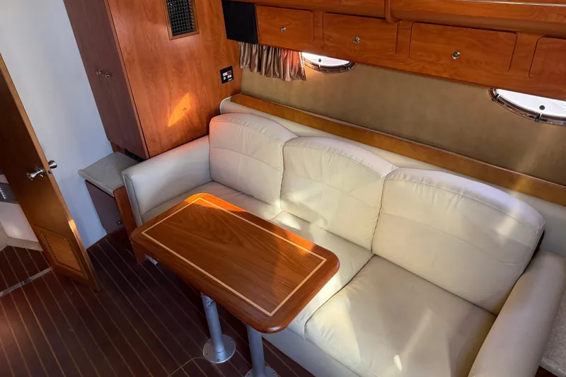 Slide: The Image of Interior of 2007 Rinker EX 370 yacht with beige sofa and wooden table. - 30