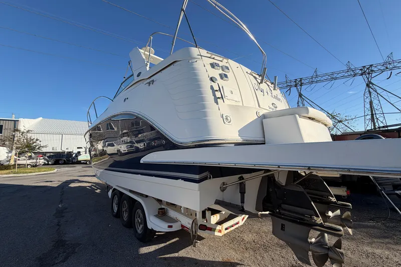 Slide: The Image of 2007 Rinker EX 370 boat on trailer, parked outdoors under clear blue sky. - 7