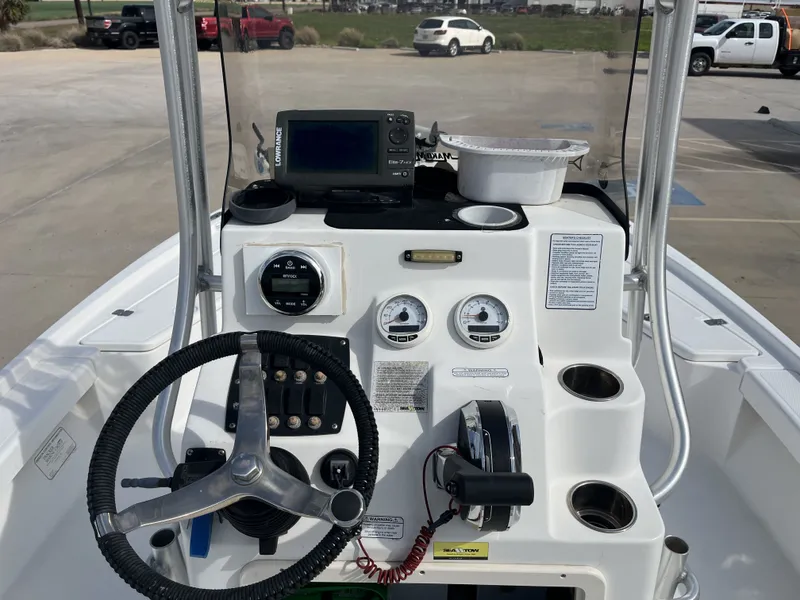 Slide: The Image of 2014 Mako 21 LTS boat console with steering wheel and instruments. - 29