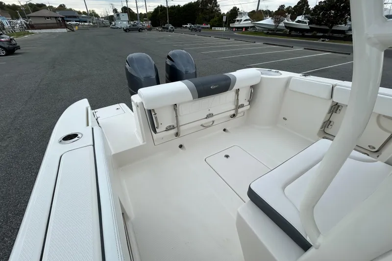 Slide: The Image of 2021 Robalo R272 Center Console boat interior with dual engines in a parking lot. - 10