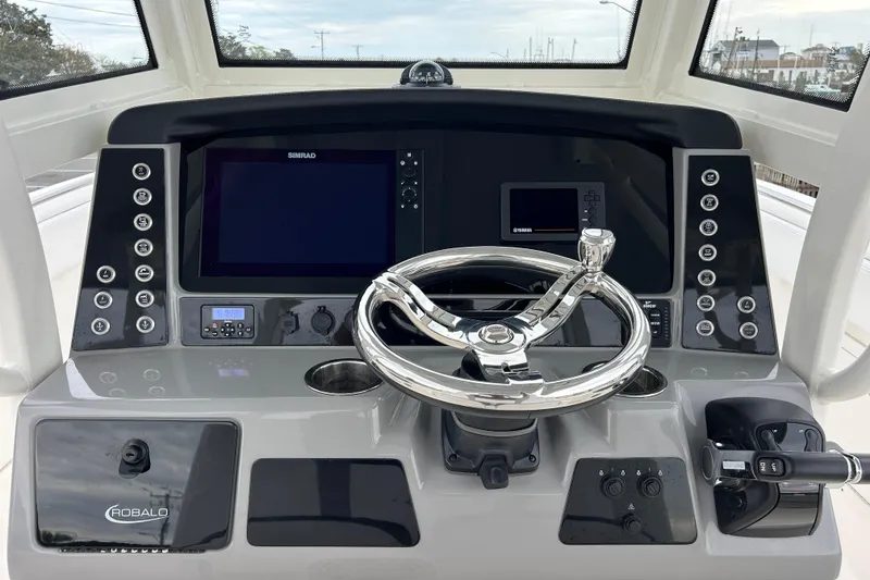 Slide: The Image of 2021 Robalo R272 Center Console helm with steering wheel and navigation controls. - 16