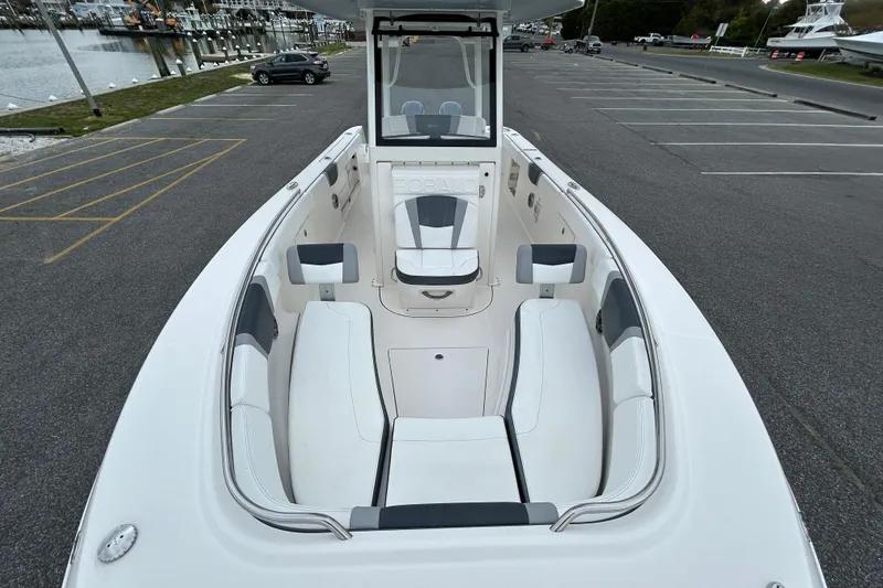 Slide: The Image of 2021 Robalo R272 Center Console boat with spacious seating, docked in a marina parking area. - 24