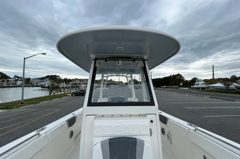 Slide: The Image of 2021 Robalo R272 Center Console boat docked near a marina under cloudy skies. - 25