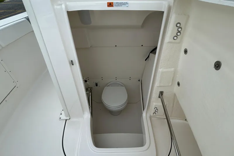 Slide: The Image of 2021 Robalo R272 Center Console boat interior with compact marine toilet. - 27