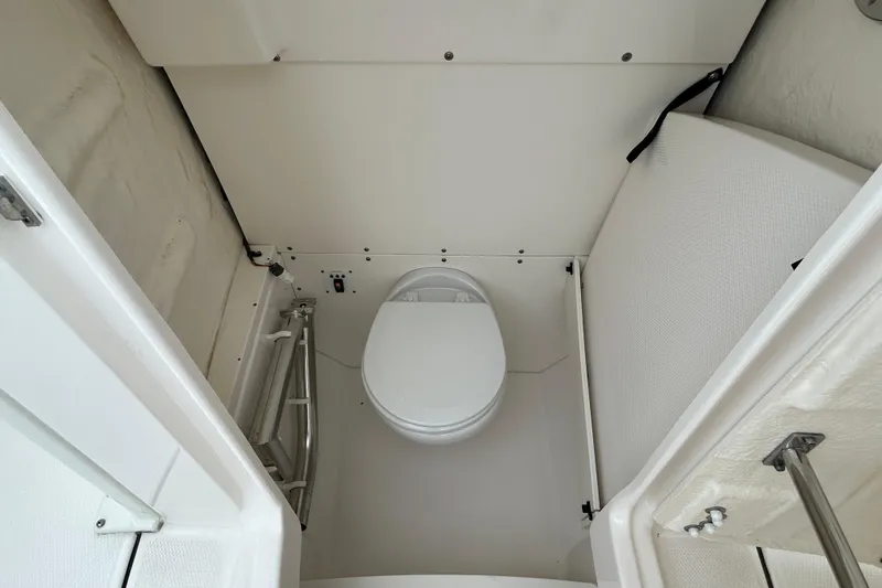 Slide: The Image of 2021 Robalo R272 Center Console boat interior with compact marine toilet. - 28