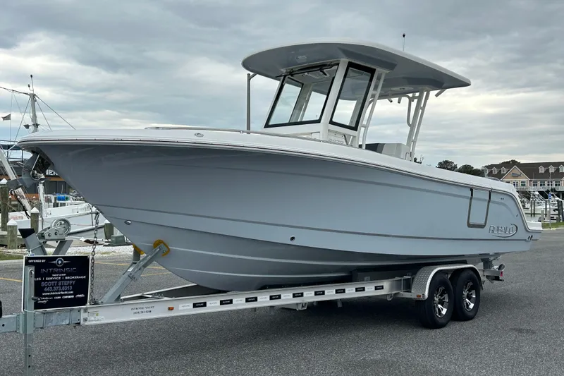 Slide: The Image of 2021 Robalo R272 Center Console boat on trailer, parked outdoors under cloudy sky. - 3