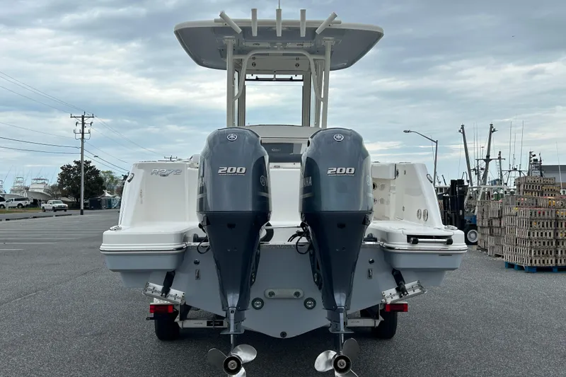 Slide: The Image of 2021 Robalo R272 Center Console boat with dual Yamaha 200 engines, parked outdoors. - 5
