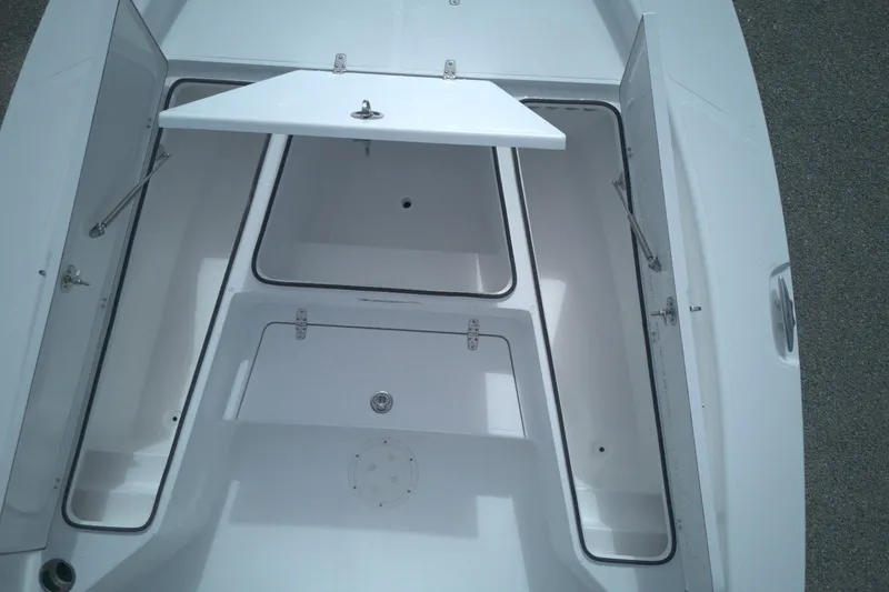 Slide: The Image of Open storage compartments on a 2026 BlackJack 256 Bay boat deck. - 6