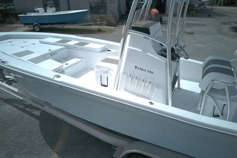 Slide: The Image of 2026 BlackJack 256 Bay boat on trailer, featuring sleek design and spacious deck. - 7