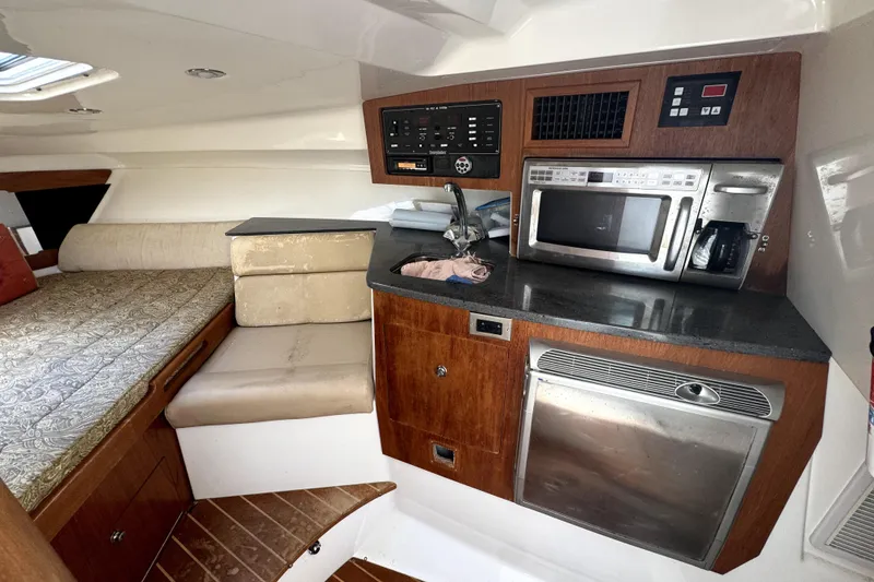 Slide: The Image of 2008 Everglades 350LX cabin interior with kitchenette, bed, and control panel. - 11