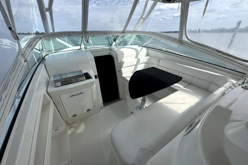 Slide: The Image of 2008 Everglades 350LX boat interior with white seating and black table, overlooking water. - 9