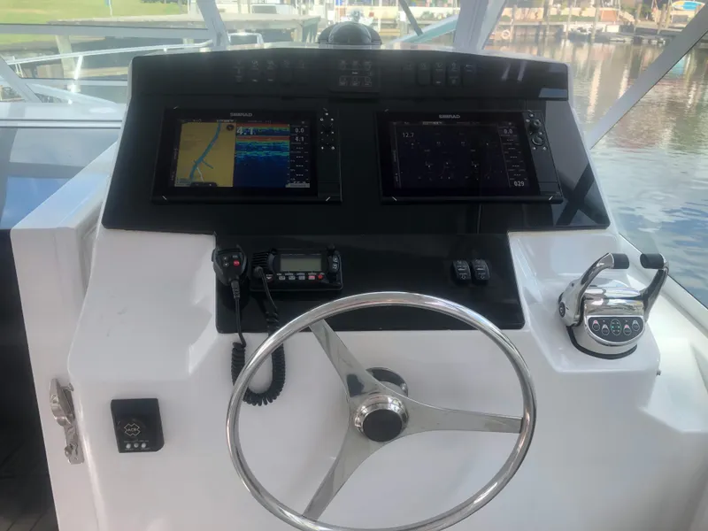Slide: The Image of 1995 Cabo 35 Express helm with navigation screens and steering wheel. - 12