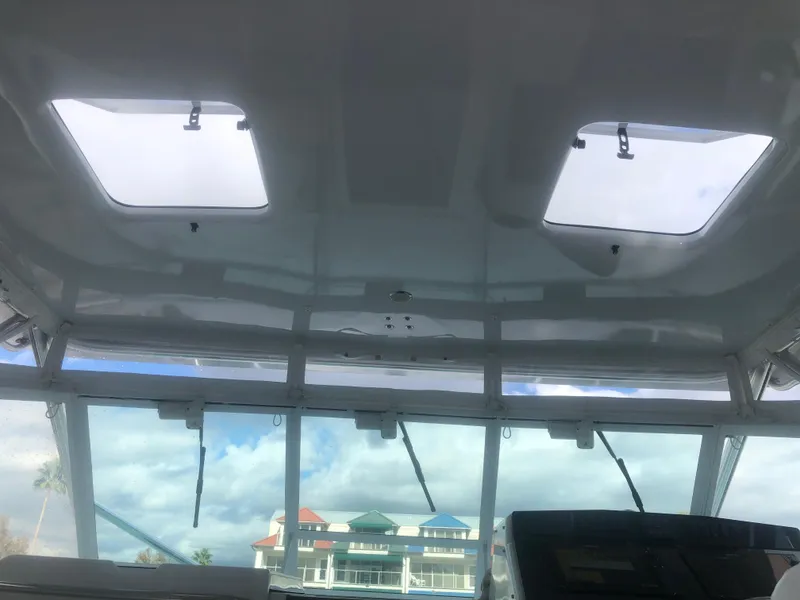 Slide: The Image of Interior view of 1995 Cabo 35 Express boat with skylights and marina backdrop. - 16