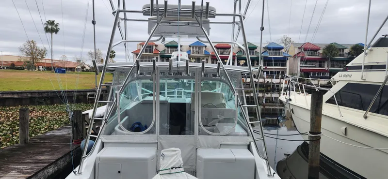 Slide: The Image of 1995 Cabo 35 Express boat docked at marina with colorful buildings in background. - 19