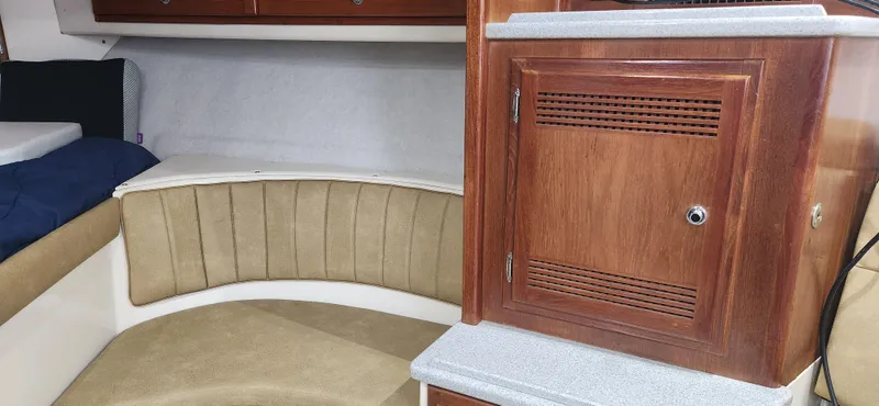Slide: The Image of 1995 Cabo 35 Express cabin interior with wood cabinetry and cushioned seating. - 22