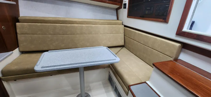 Slide: The Image of 1995 Cabo 35 Express interior with beige seating and a small table. - 28
