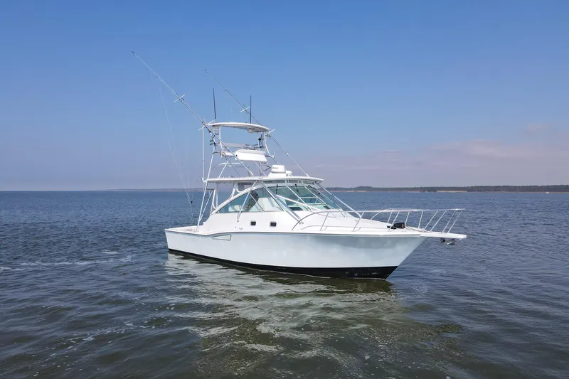 Slide: The Image of 1995 Cabo 35 Express boat on calm water under clear blue sky. - 3