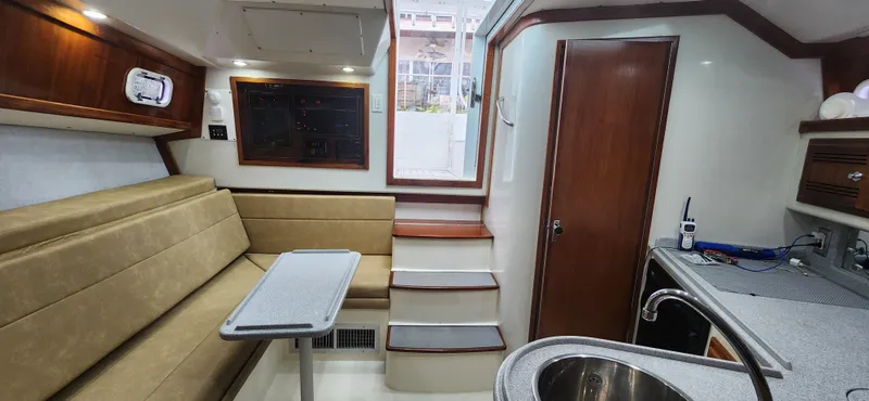 Slide: The Image of Interior of 1995 Cabo 35 Express boat with seating, table, and kitchenette. - 30