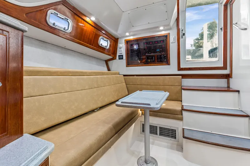 Slide: The Image of Interior of 1995 Cabo 35 Express boat with beige seating and wooden accents. - 34