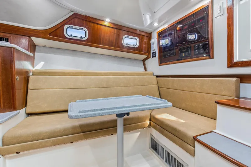 Slide: The Image of Interior of 1995 Cabo 35 Express boat with beige seating and control panel. - 35