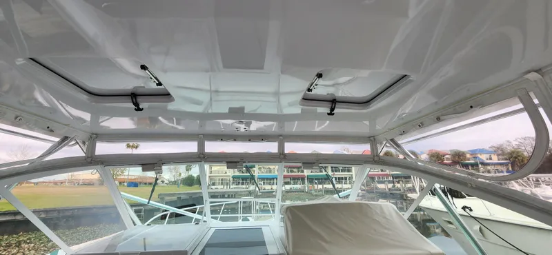 Slide: The Image of Interior view of a 1995 Cabo 35 Express boat with marina background. - 40