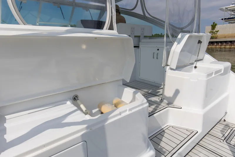 Slide: The Image of 1995 Cabo 35 Express boat interior with open storage compartments and clean deck. - 42