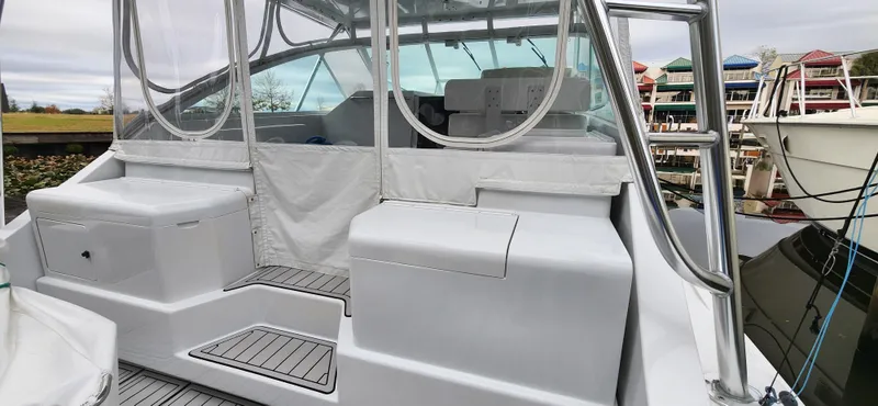 Slide: The Image of 1995 Cabo 35 Express boat with covered seating and marina background. - 47