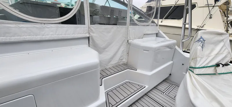 Slide: The Image of 1995 Cabo 35 Express boat interior with seating and covered deck area. - 49