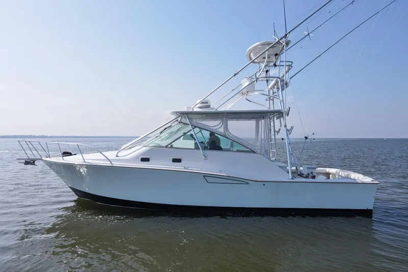 Slide: The Image of 1995 Cabo 35 Express boat on calm water, side view, clear sky. - 68