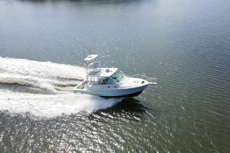 Slide: The Image of A 1995 Cabo 35 Express boat cruising swiftly on open water. - 74