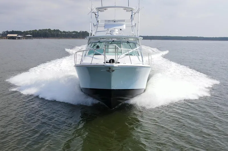 Slide: The Image of 1995 Cabo 35 Express boat cruising on open water, creating a dynamic wake. - 8