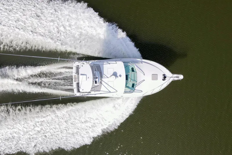 Slide: The Image of Overhead view of a 1995 Cabo 35 Express boat cruising on water. - 9