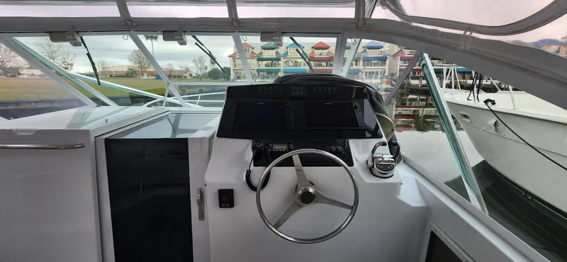 Slide: The Image of 1995 Cabo 35 Express boat helm with steering wheel and navigation equipment. - 13