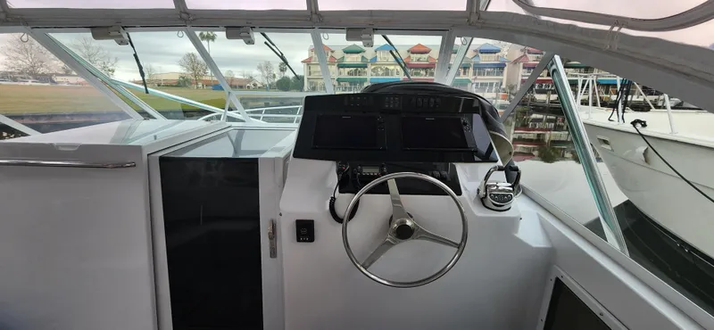 Slide: The Image of 1995 Cabo 35 Express boat helm with steering wheel and navigation equipment. - 15