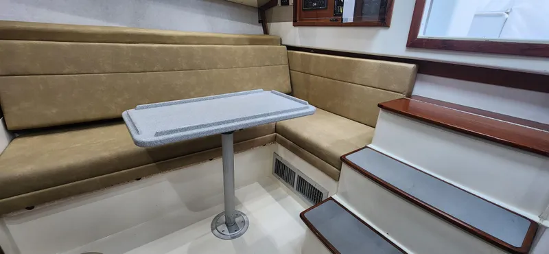 Slide: The Image of 1995 Cabo 35 Express interior with beige seating, table, and stairs. - 21